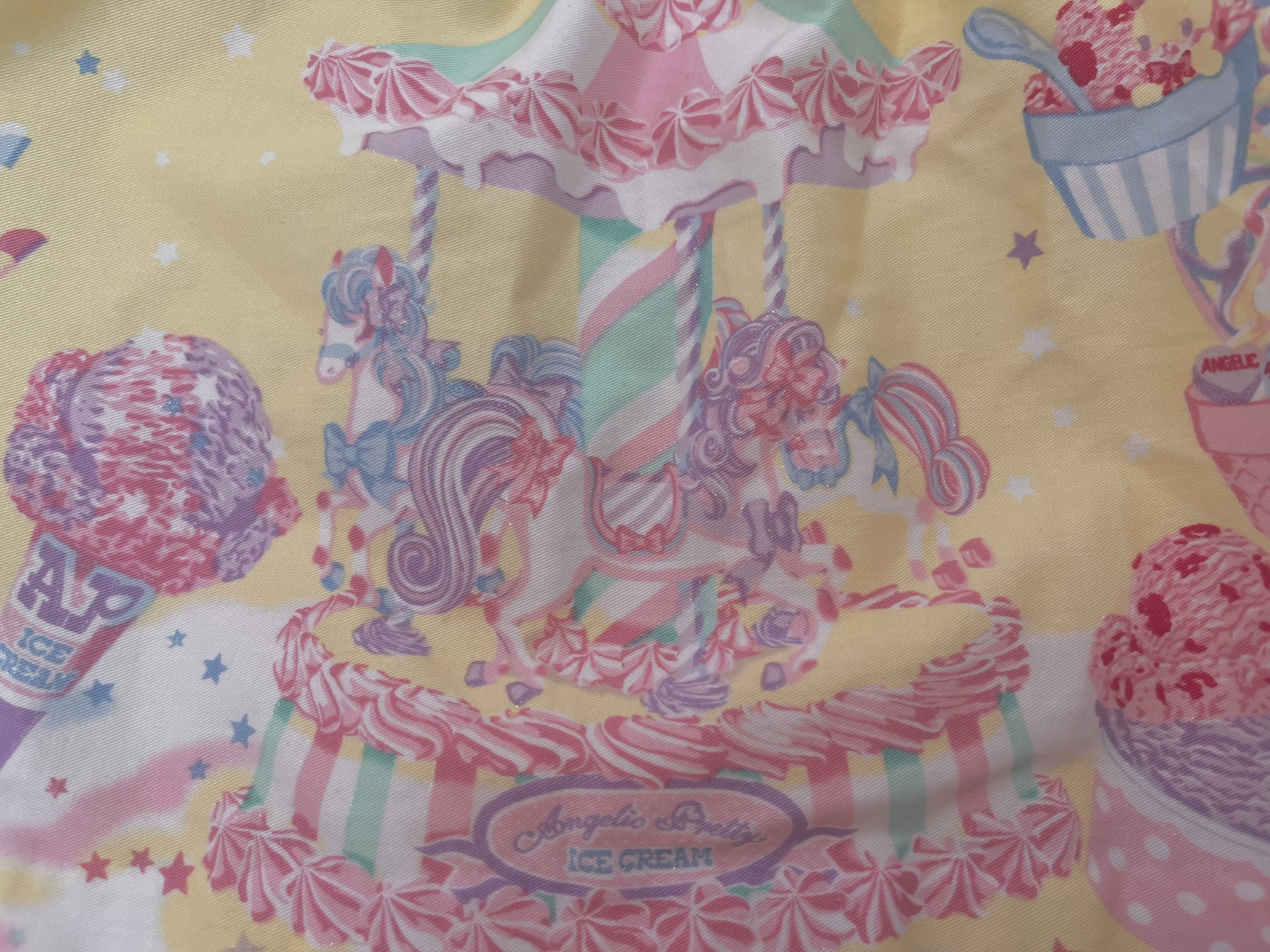An up-close photo of the carousel on Milky Planet's border print. The horses are pastel and glittery.