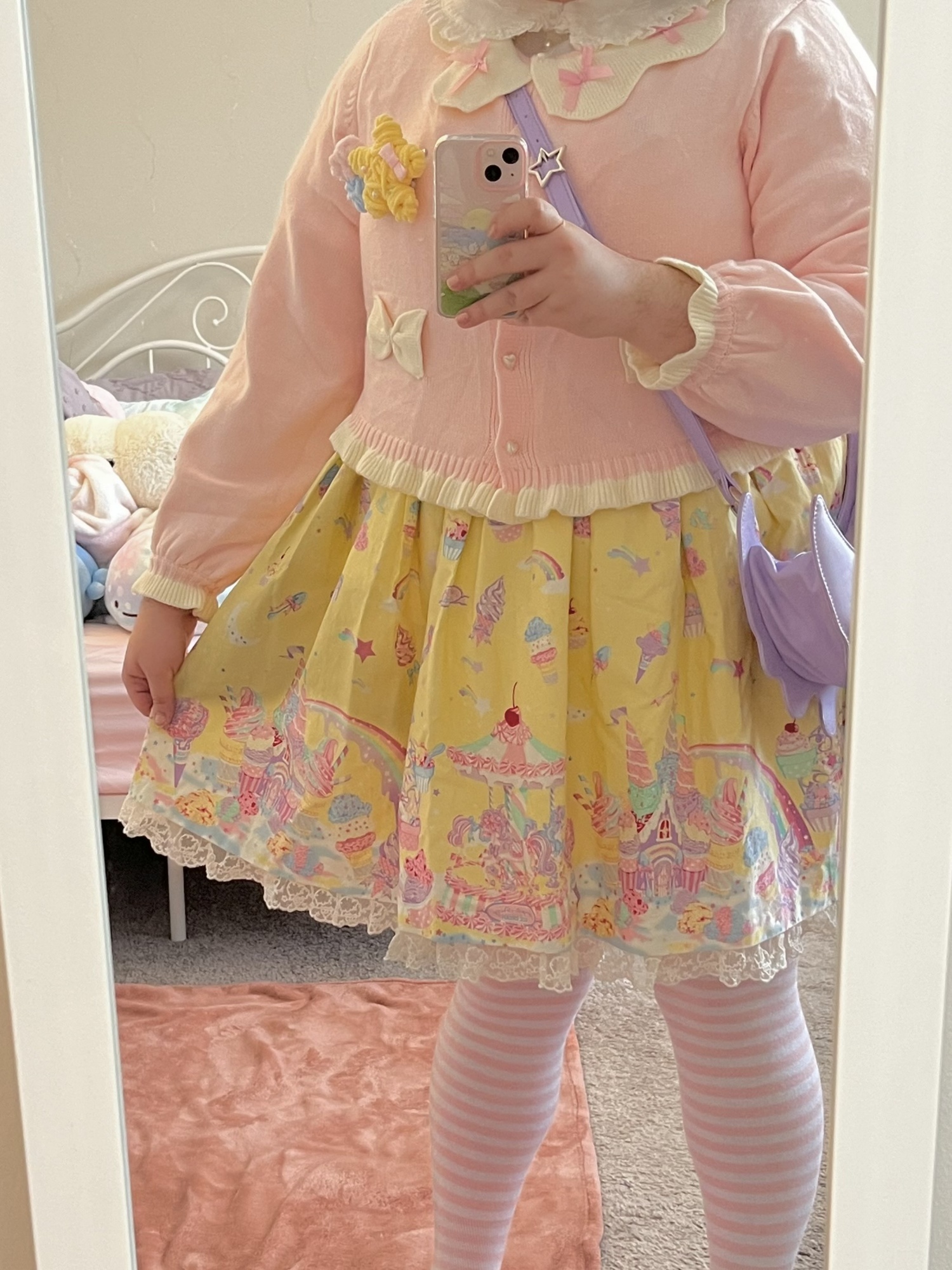 A selfie of me wearing Milky Planet alongside a pink cardigan and purple bag. My head is not visible in the photo. I am holding the skirt out to puff it up in the photo.